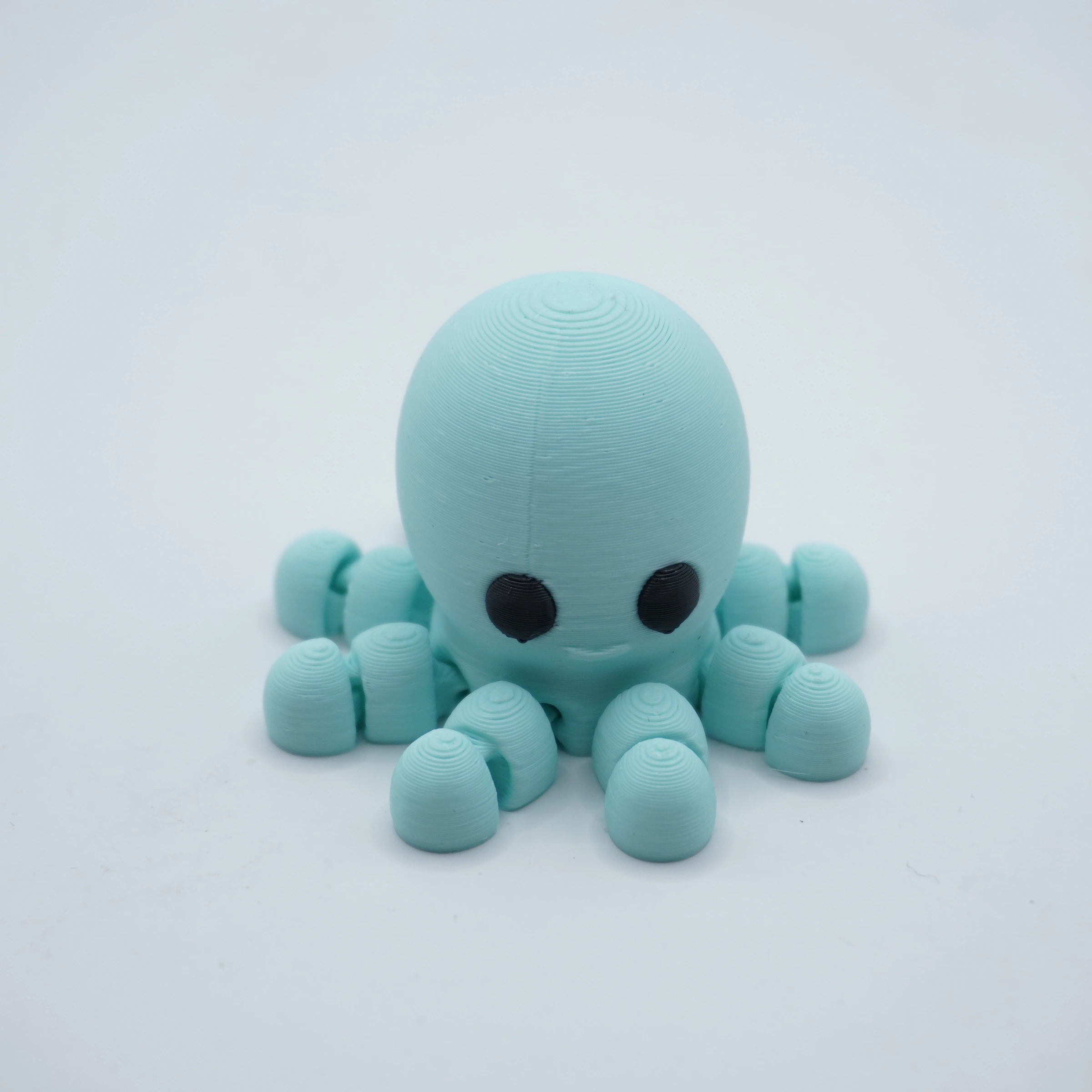 pulpo-articulado-pla-celeste Pulpo articulado impreso en 3D en PLA+ celeste, tentáculos segmentados