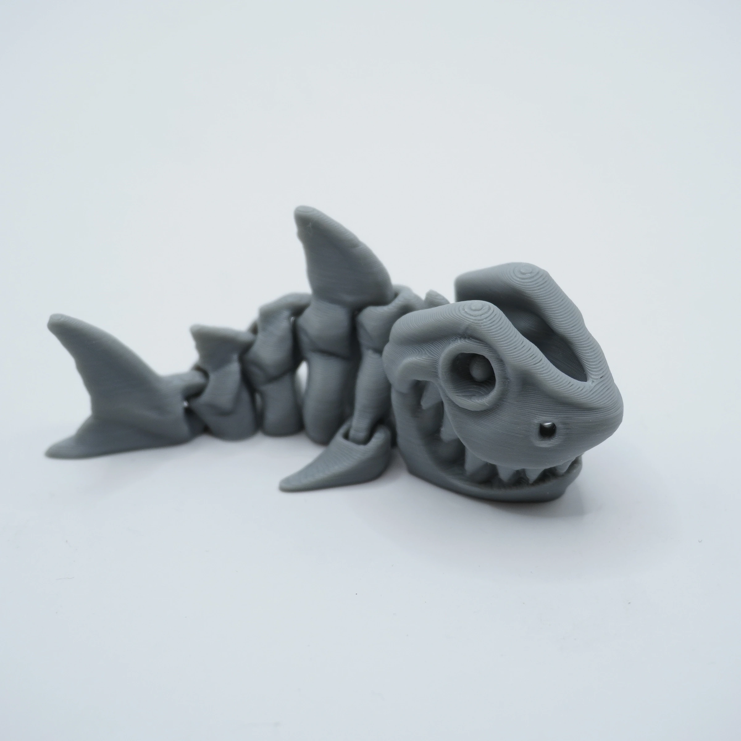 tiburon-articulado-pla-gris iburón articulado impreso en 3D en PLA+ gris, cuerpo segmentado y aleta dorsal